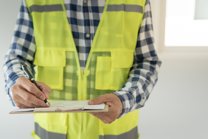 inspector reviewing construction and quality assurance of house using a checklist. 

