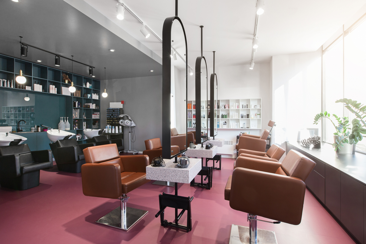 Workplace for cosmetologists doing makeup and hair. Big mirrors and leather chairs, beauty salon interior


